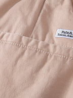 Chino-shortsien takataskun ja merkkilapun yksityiskohta