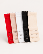Conjunto de cinco extensores de soutien em vermelho, rosa, branco, preto e bege sobre fundo off-white