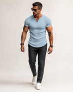 Modelo adulto de corpo inteiro com camisa Henley masculina canelada azul-clara em estúdio off-white