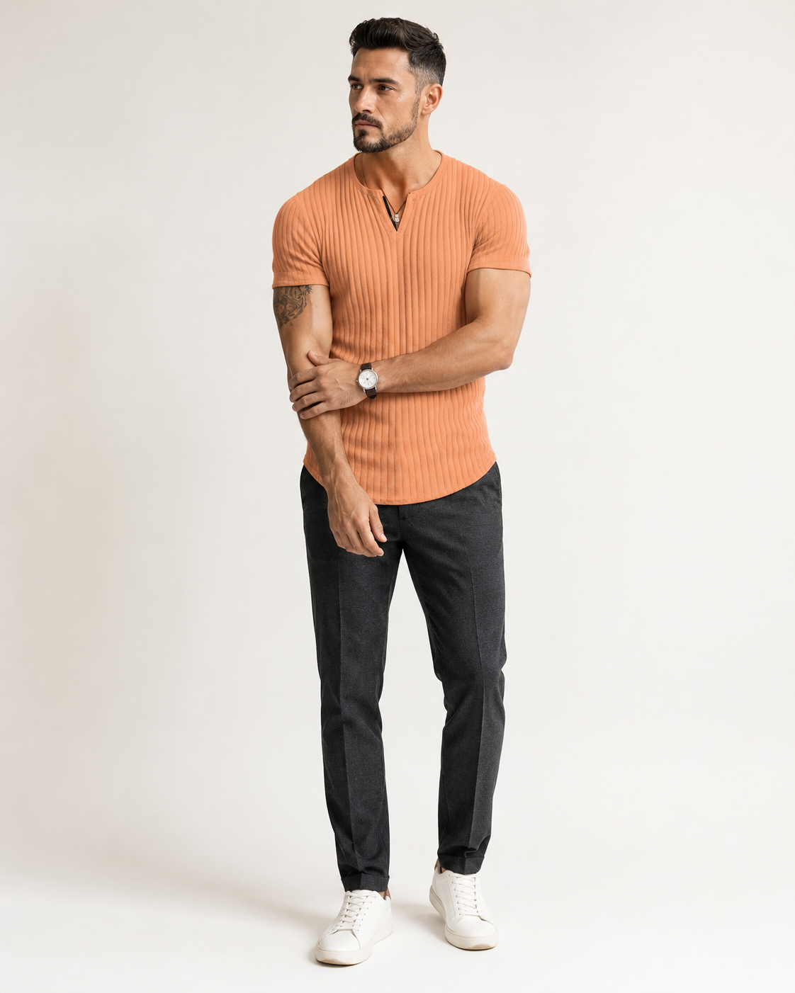 Modelo adulto de corpo inteiro com camisa Henley masculina canelada laranja em estúdio off-white