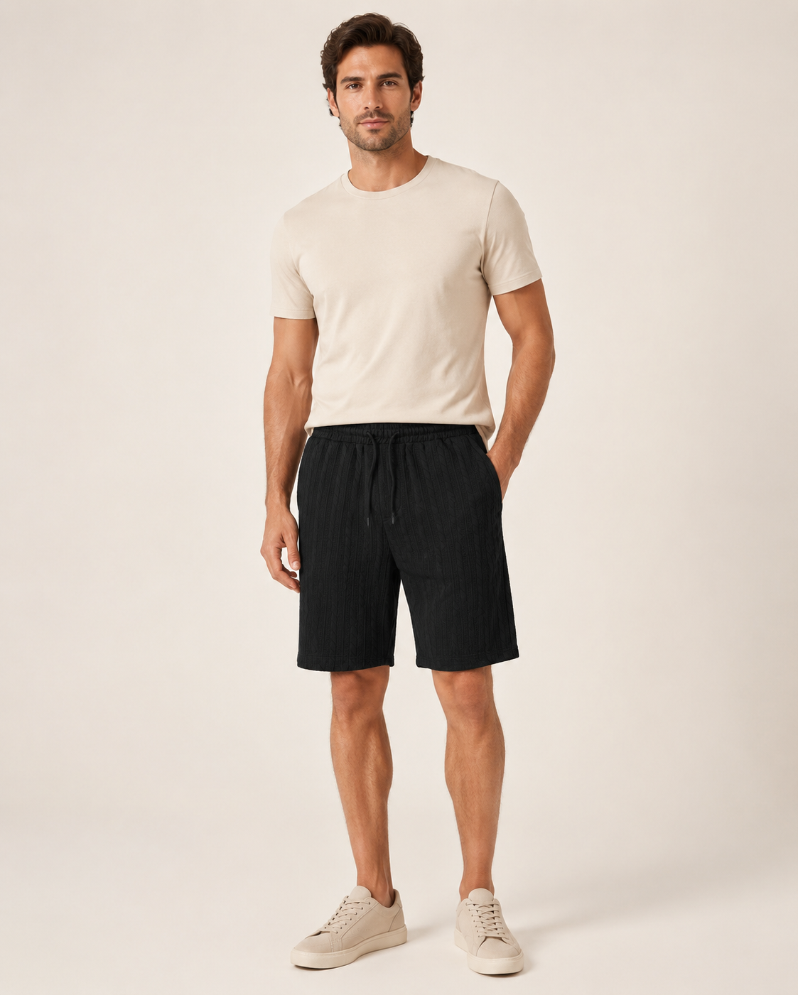 Male model wearing black cable-jacquard drawstring shorts in a neutral studio