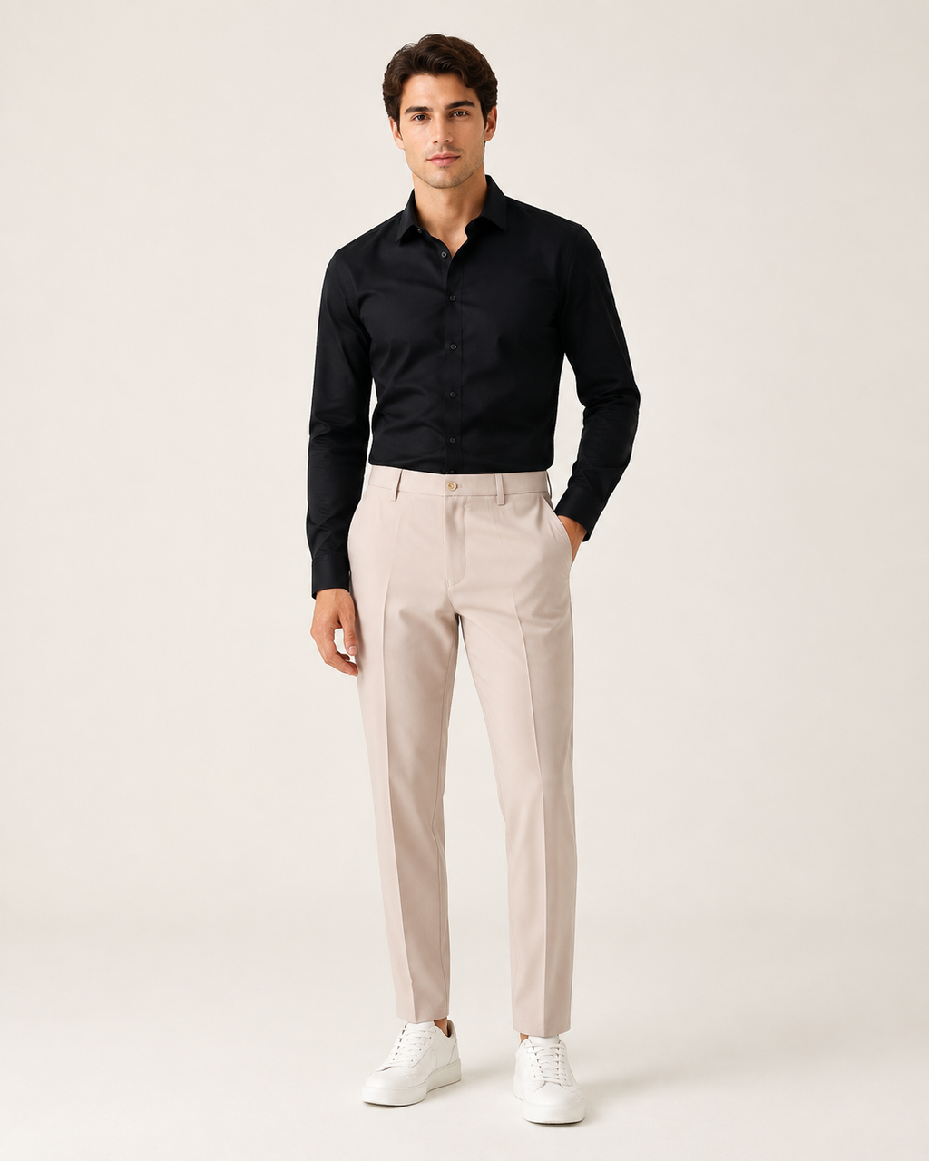 Miesmalli beigenvärisissä kapenevissa slim fit -housuissa vaaleassa studiossa