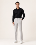 Miesmalli hopeanharmaissa kapenevissa slim fit -housuissa vaaleassa studiossa
