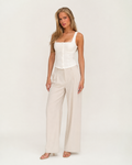 Modelo adulto de corpo inteiro com top branco estruturado de decote quadrado e botões em estúdio off-white